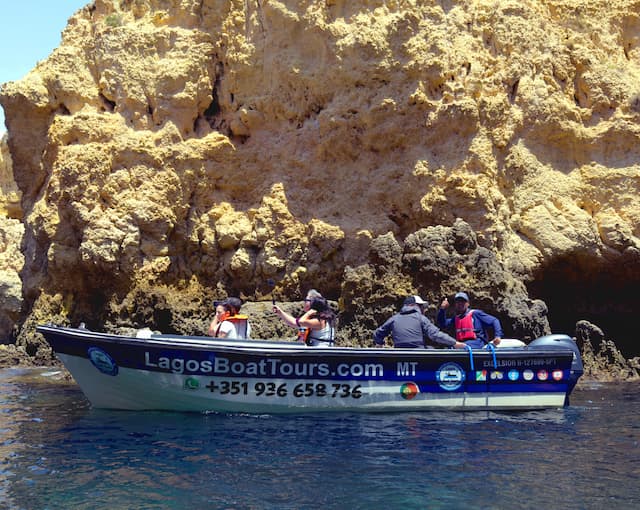 Lagos Boat Tours boat below golden cliffs at Ponta da Piedade